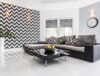 Posh living room with white tiled floor and black lounge set